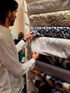 Nick Gallardo reviewing patterned decorative fabric swatches at Global Incentives Manufacturing
