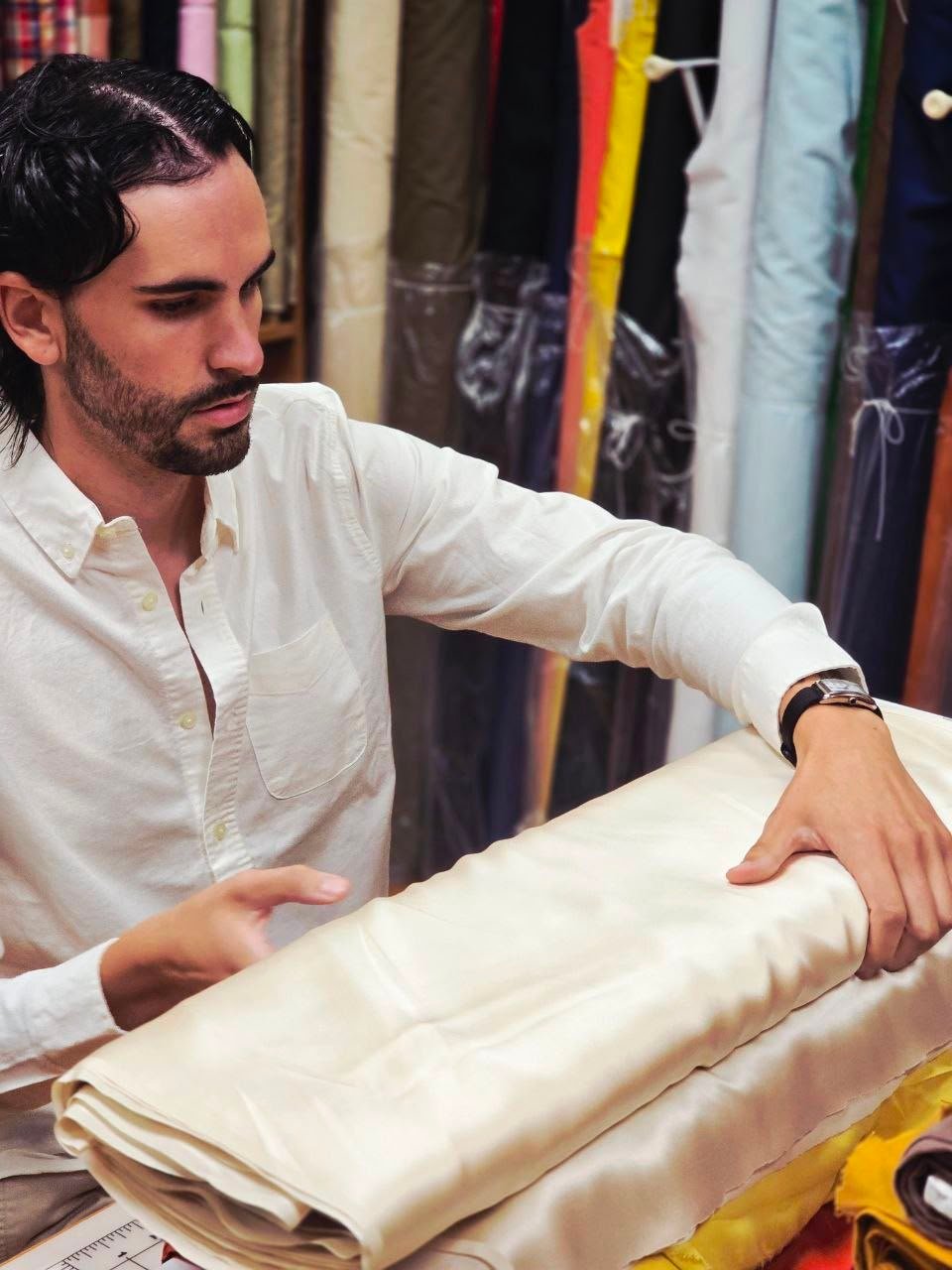 Nick Gallardo assessing folded satin textile fabric at Global Incentives Manufacturing